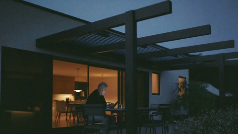 Zákazník večer pod pergolou hledá v telefonu cenu